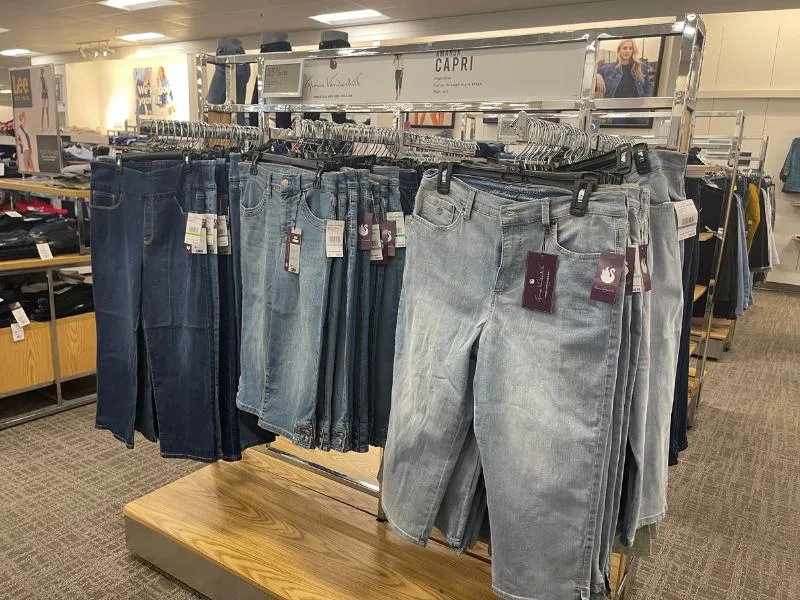 Capri pants displayed on hangers in a department store, illustrating their return to retail despite being an unflattering style.